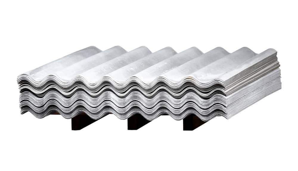 A stack of wave slate on a wooden flight isolated on a white background. Gray wavy slate. Slate Roofing. Corrugated roof, profiled sheeting.